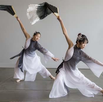 Lors d'un événement organisé au musée, une Indienne vêtue d'un sari sert un curry à une jeune femme d'origine européenne.