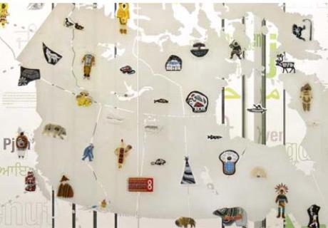 Une grande carte de l’Île de la Tortue sur un mur en verre, arborant plusieurs œuvres d’art autochtone en verre.