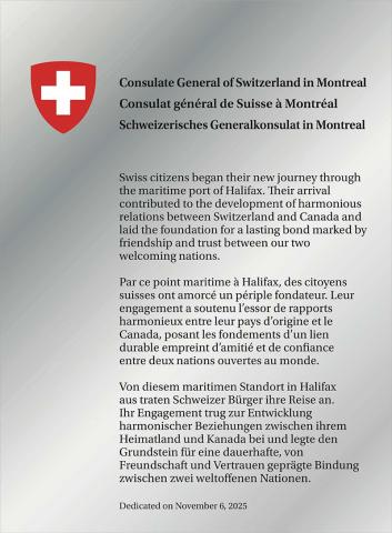 Plaque argentée brillante avec un écusson et un texte.