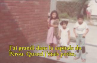 Trois petits enfants se tiennent devant un bâtiment.