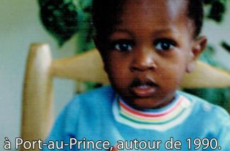 Un petit garçon mignon dans un pull turquoise est assis dans une chaise.