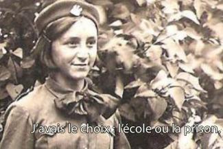 Une jeune fille en uniforme se lève et sourit.