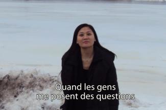 Une jeune femme se tient devant un lac glacé.