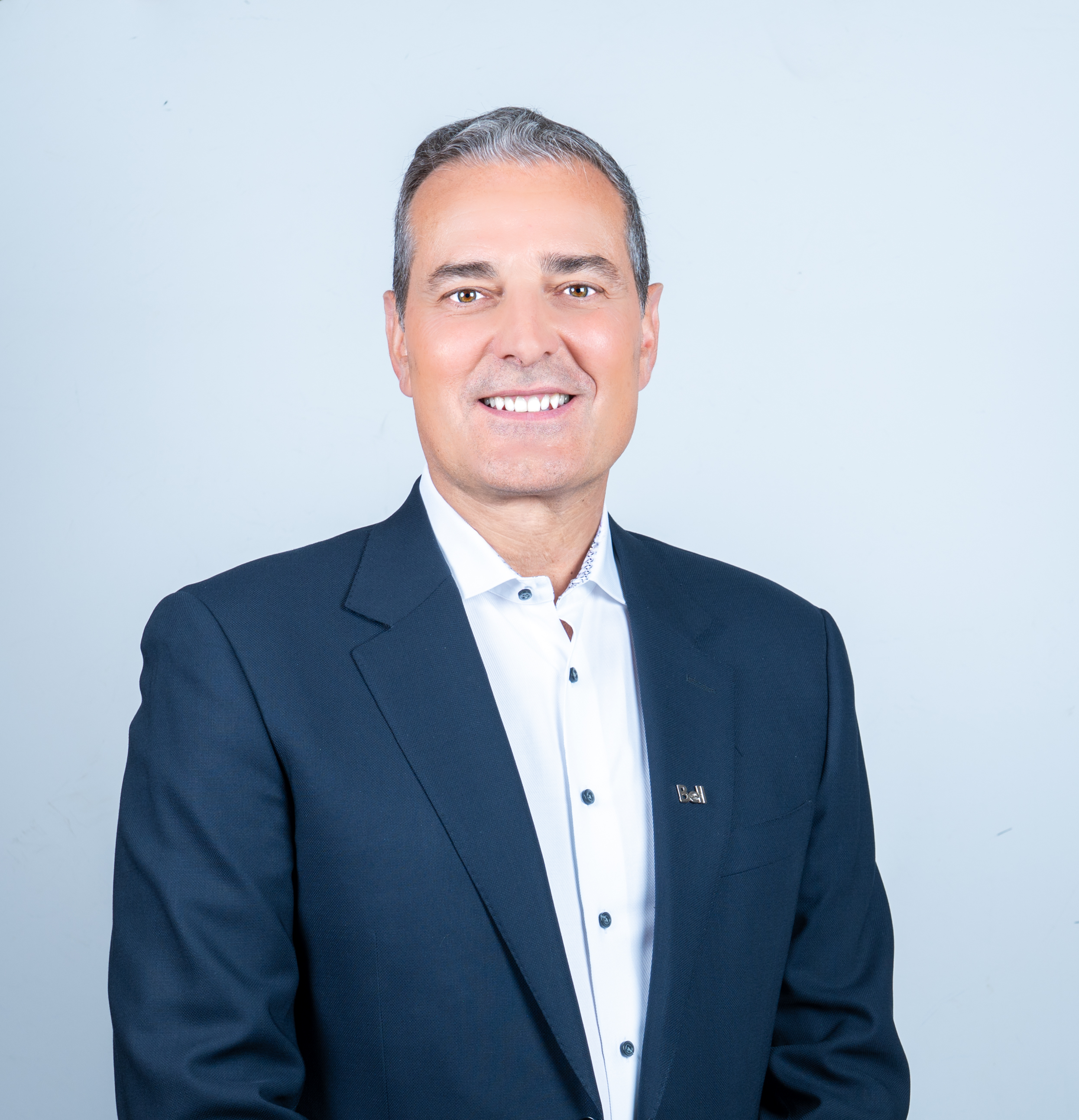 Portrait de Mirko Bibic en costume, souriant.