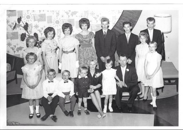 Groupe bien habillé de membres de la famille assis et debout pour la photo.