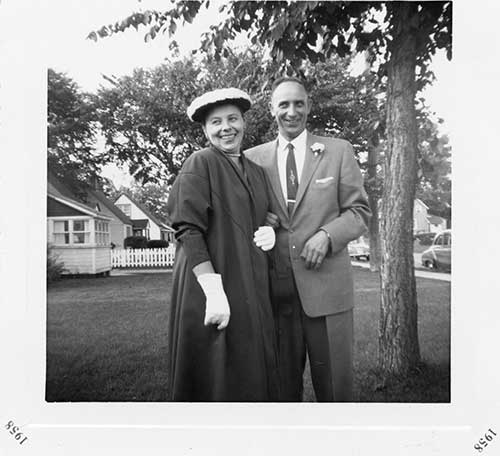 Vieille photo noire et blanche de couple souriant soutenant d'un arbre