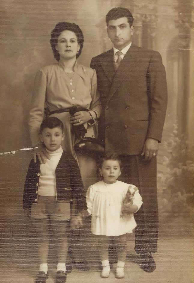 Portrait de famille montrant la mère, le père, le fils et la fille. Les deux enfants tiennent des ours en peluche.