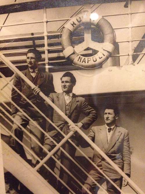 Image sépia de trois hommes debout sur différents niveaux d’un escalier.