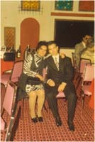 Homme et femme bien habillés assis dans une salle de cérémonie.