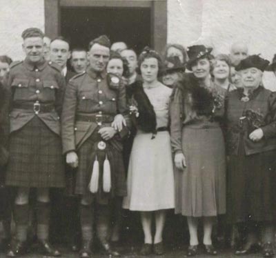 Photo de groupe d’un jour de mariage, avec les hommes en kilt traditionnel.