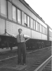 Bernardus en veste et chemise, avec une main sur le train.