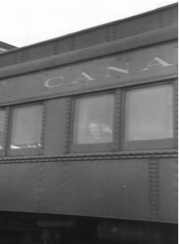 Personne assise, faisant un signe de la main d’une fenêtre d’un train.