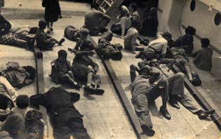 Jeunes gens accoudés sur le pont d’un bateau.