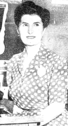 Femme assise, portant une robe à pois.