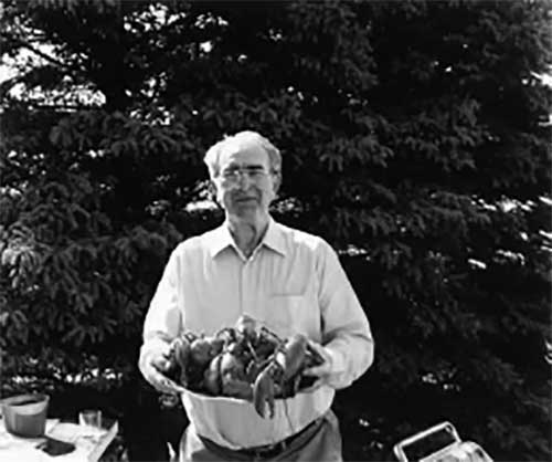 Un homme fier avec un énorme seau de homards.