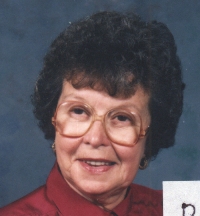 Portrait de tête de Daphné plus âgée, portant des lunettes et un haut bordeaux.