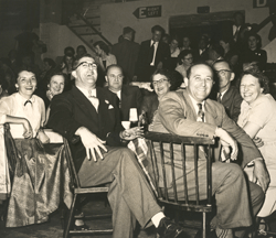 Large groupe de personnes assises et souriant et riant devant l’appareil photo.