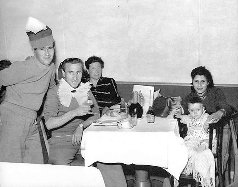 La photographie en noir et blanc du 15 juin 1953 montre un dîner de groupe à bord du navire de passagers Saturnia.