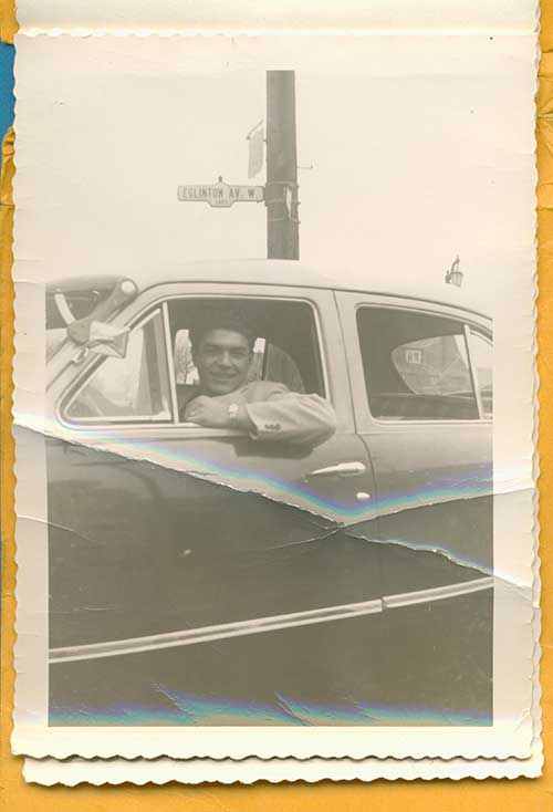 Un jeune homme regarde par la fenêtre d’une voiture.