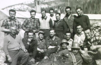 Large groupe d’hommes à l’extérieur, certains portant des casques de protection.