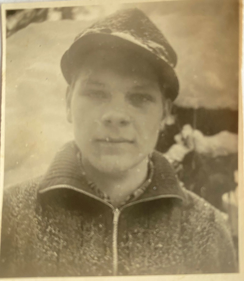Le jeune homme se tient debout et la neige tombe sur lui.