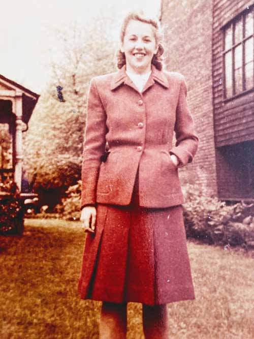 Une jeune femme bien habillée pose pour une photo.