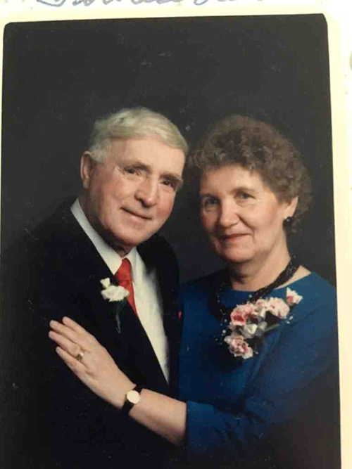 Un couple d’âge moyen portant des corsages posent pour la caméra.