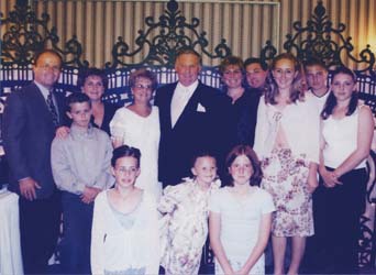 Photo de famille récente avec enfants devant et adultes derrière.
