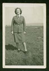 La jeune Joan en tenue militaire, debout au loin à l’extérieur.