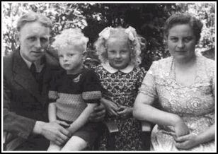 Une mère et un père et leurs deux enfants blonds entre eux.