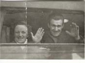 John et Kiersten faisant signe à la caméra, par la fenêtre du train.
