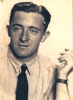 Cecil plus âgé, en costume gris et cravate bourgogne.