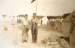 Photographie décolorée montrant deux hommes tenant du poisson.