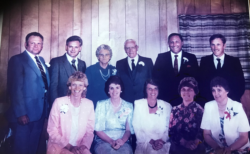 Neuf frères et sœurs adultes posent pour une photo avec leurs parents.