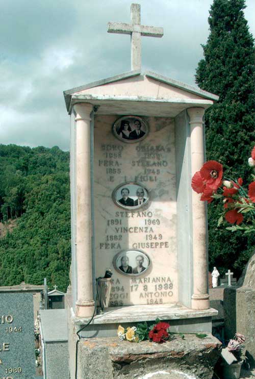 Terrain familial dans un cimetière avec grande pierre tombale et beaucoup d’arbres dans le fond.