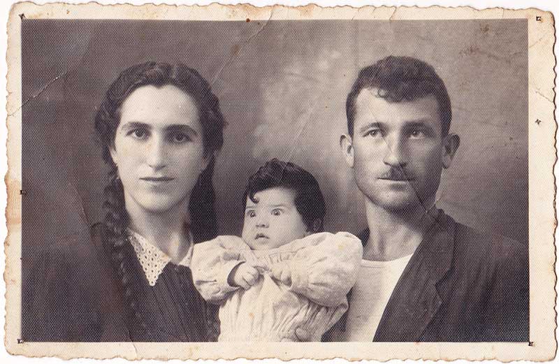 Vieille photo en noir et blanc d’un jeune couple avec leur bébé.