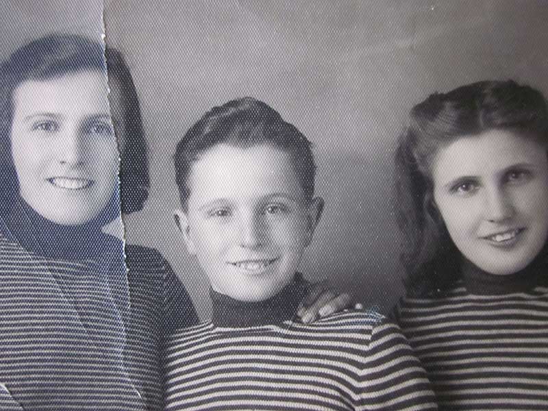 Une vieille photo craquelée montrant une femme et un enfant. Un deuxième enfant est coupé et ne peut pas être vu.