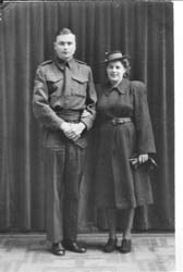 Photo pleine longueur d’un homme et d’une femme debout devant le rideau, une femme tenant une paire de gants.
