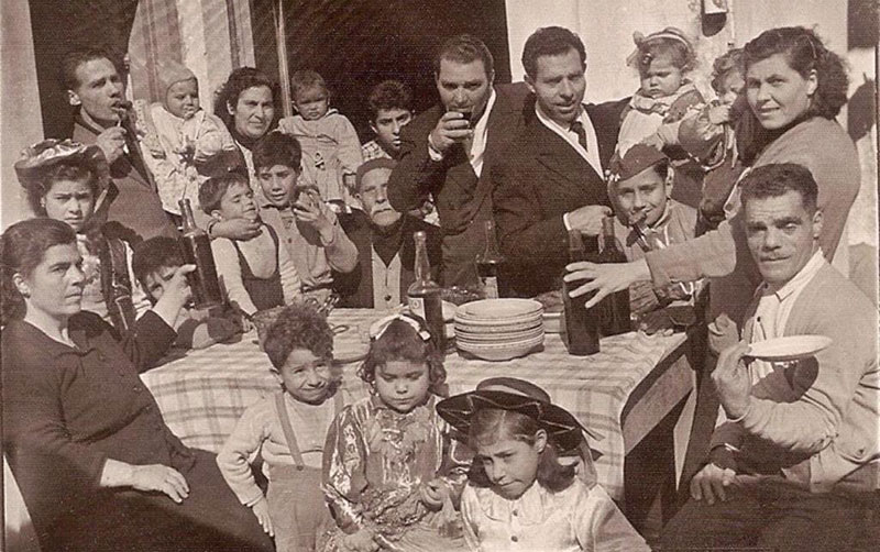 Grand groupe d’adultes et d’enfants assis autour d’une table.