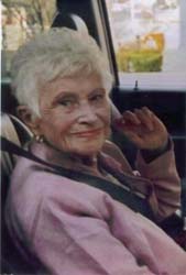 Muriel était assise sur le siège passager, habillée en rose.