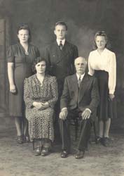 FPortrait de famille avec mère et père assis, trois enfants adultes debout derrière.