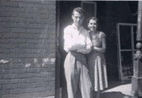 Homme et femme debout sur le porche de la maison.