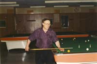 Photographie couleur de Nikolas plus âgé, se préparant à jouer au billard.