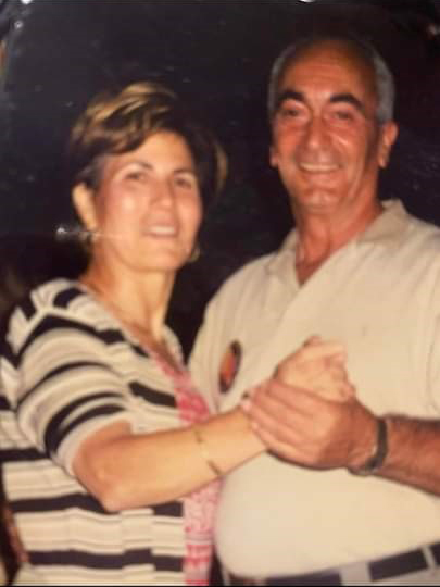 Un homme et une femme dansent et sourient à la caméra.