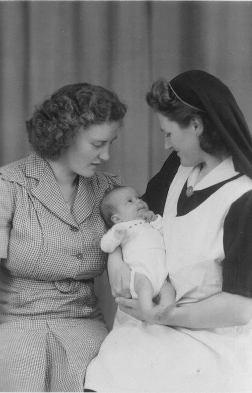 Deux belles dames regardent un petit bébé.