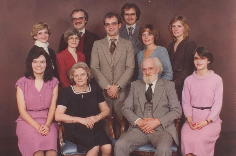 Membres de la famille bien habillés assis et debout pour la photo de groupe.