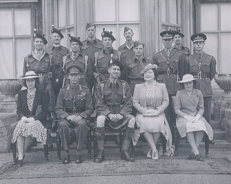 Un groupe d’hommes de l’armée soutient les membres de la famille royale.