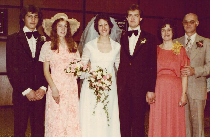 Une belle mariée en robe de mariée avec sa famille autour d’elle.