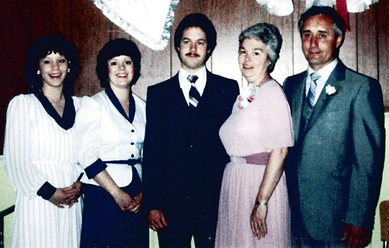 Un marié se tient le jour de son mariage, entouré de sa famille.