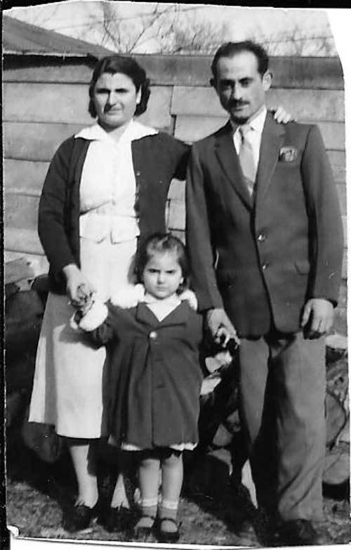 Homme et femme se tiennent avec un enfant entre eux et chacun tient sa main.